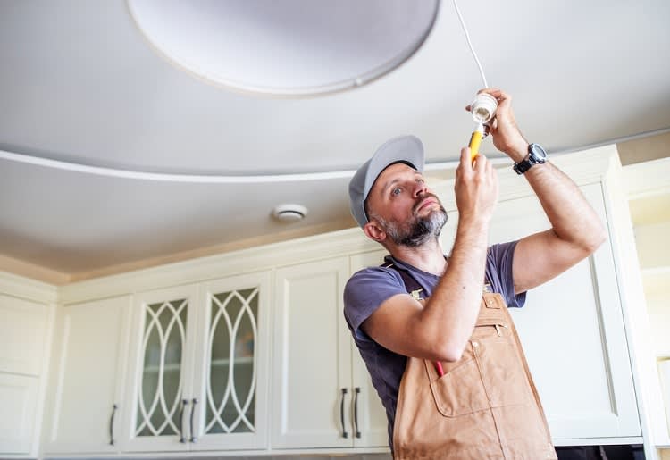 Electrician repairing light fixture