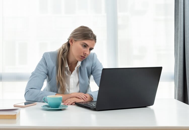 Unhappy person looking at a laptop.
