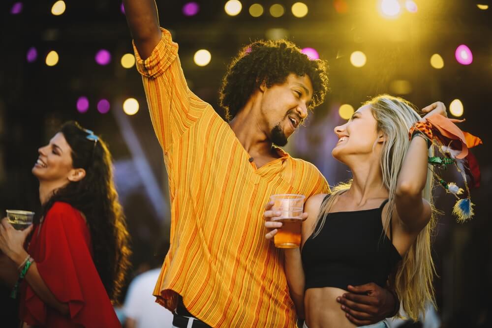 A happy couple smiling at one another while at a festival