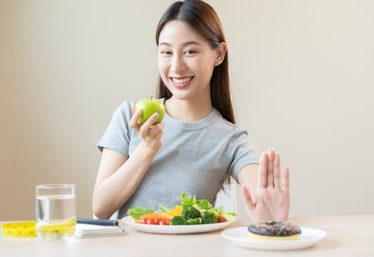 a woman sitting at a table with a plate of food