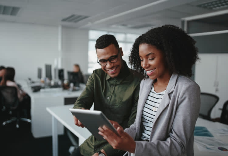 Man and woman working together on a tablet.